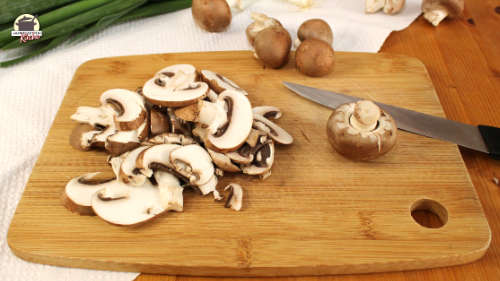Geschnittene Champignons auf einem Holzbrett