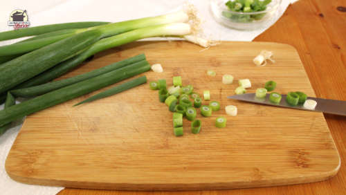 Geschnittene Lauchzwiebeln auf einem Holzbrett
