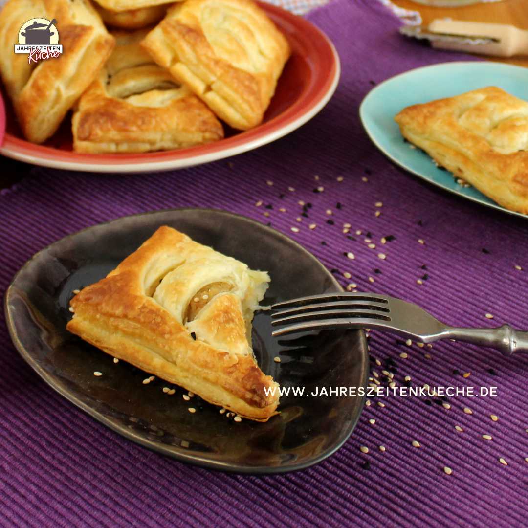 Auf einem kleinen Teller liegt eine Blätterteigtasche mit Kartoffelfüllung