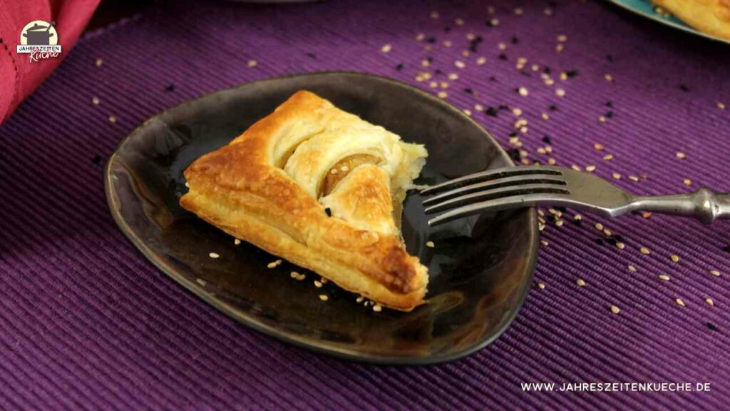 Auf einem kleinen Teller liegt eine Blätterteigtasche mit Kartoffelfüllung