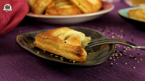 Auf einem kleinen Teller liegt eine Blätterteigtasche mit Kartoffelfüllung