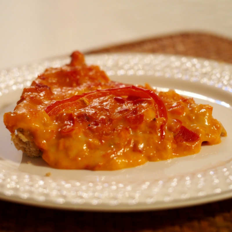 Ein Stück vegane Paprikaquiche liegt auf einem weißen Teller