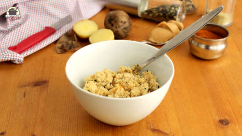 In einer Schüssel ist die fertige Kartoffelnfüllung mit Erdnussmus, Chili, Sesam und schwarzkümmel.