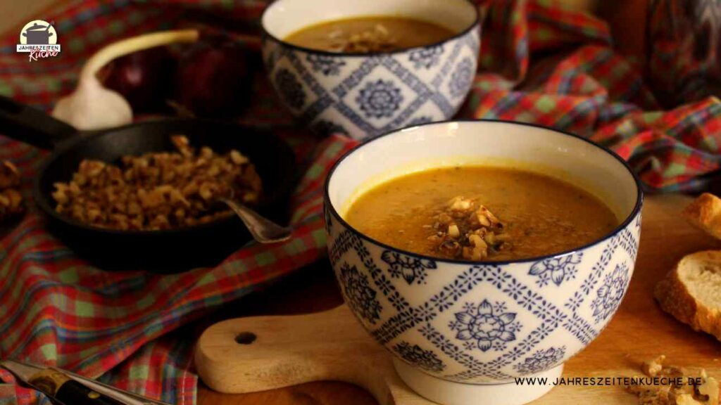 Eine Portion Karotten-Zucchini-Suppe mit Walnuss-Crunch ist in einem Schälchen angerichtet