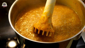 Karotten-Zucchini-Suppe wird mit einem Pürierstab zerkleinert