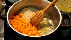 Kürbis, Reis und Zwiebeln in Öl anschwitzen