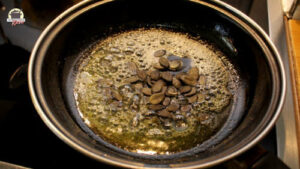 Kürbiskerne werden in Butter in einer Pfanne geröstet