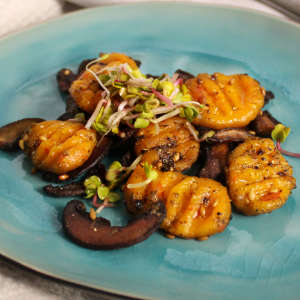 Ein türkisfarbener Teller mit Kürbis-Gnocchi und gebratenen Champignons