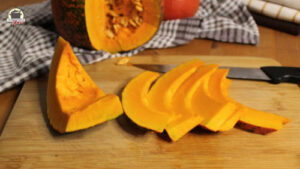 In Scheiben geschnittener Hokkaido-Kürbis liegt auf einem Holzbrett