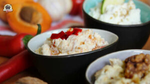 In einem dunklen Keramik-Schälchen ist Frischkäse mit Aprikose und Chili angerichtet