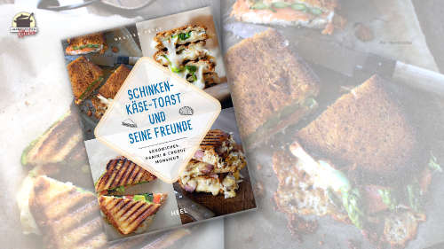 Das Kochbuch Schinken-Käse-Toast und seine Freunde von Bastien Petit vor zwei aufgehellten Buchseiten