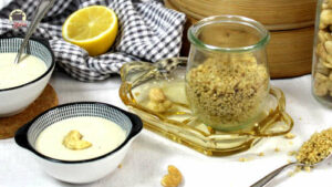 Vegane Pastasaucen und Toppings, wie veganer Parmesan und Cashewcreme stehen auf einem weißen Tisch.