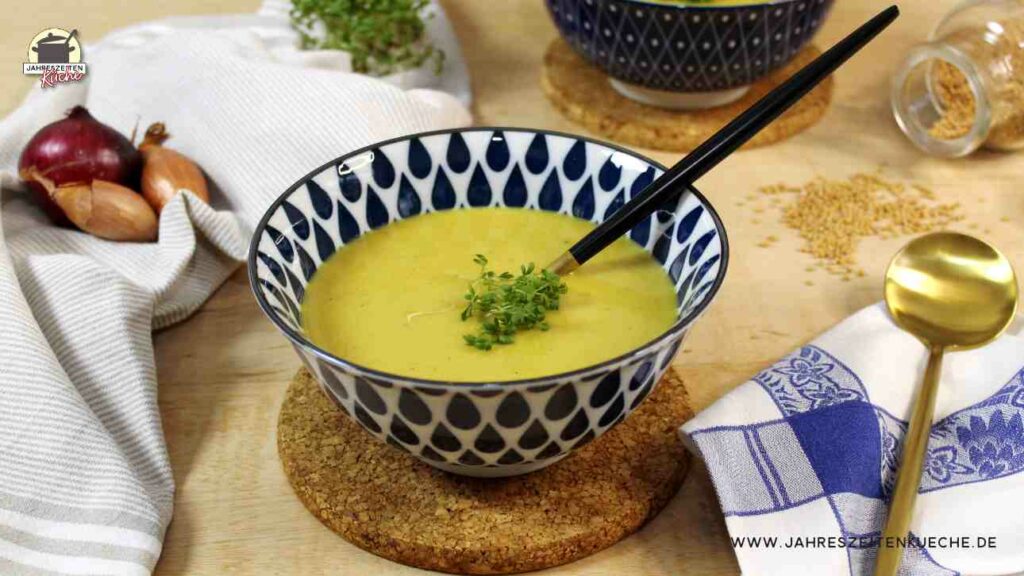 Eine blaugemusterte Schüssel mit würziger Kartoffelsuppe, auf der frische Kresse liegt.