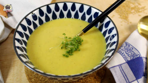 Eine blaugemusterte Schüssel mit würziger Kartoffelsuppe, auf der frische Kresse liegt.