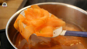 Blanchierte Karotten auf einem Schaumlöffel