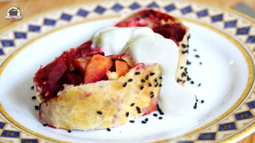 Auf einem Teller mit blaugelbem Rand liegt ein Stück Rote-Bete-Strudel mit Joghurtdressing