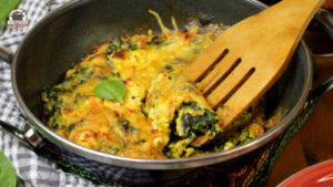 Gebackenes Spinat-Frittata in einer Pfanne mit Holzlöffel
