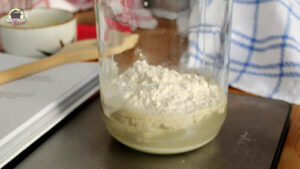 Mehl und Wasser in einem Glas für das Sauerteig Grundrezept