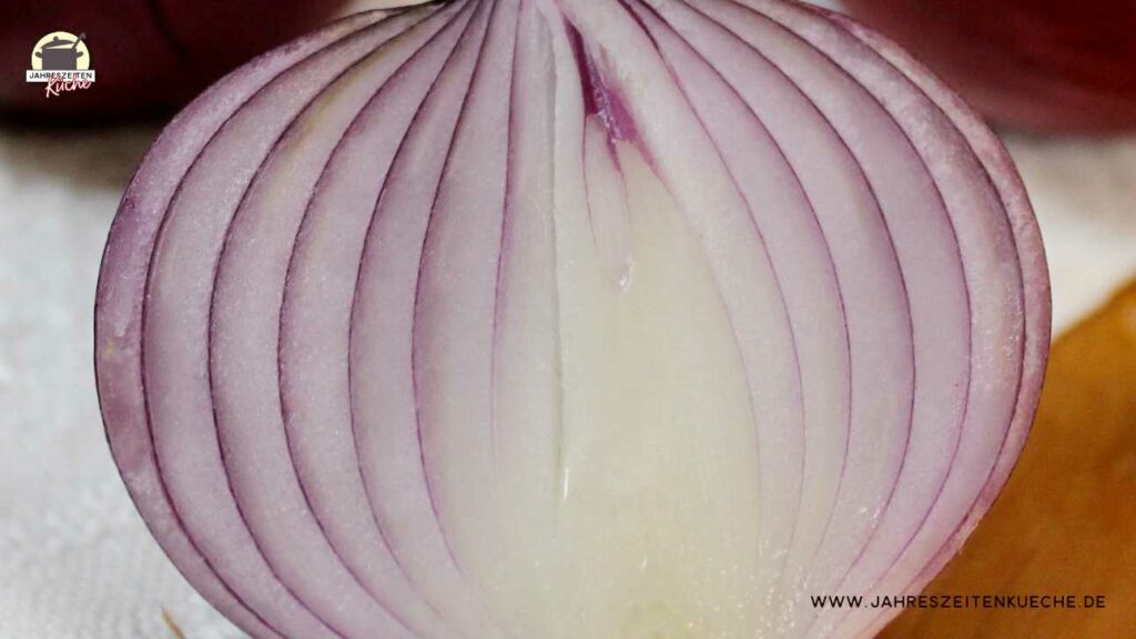 Von einer halbierten roten Zwiebeln ist die Schnittfläche zu sehen